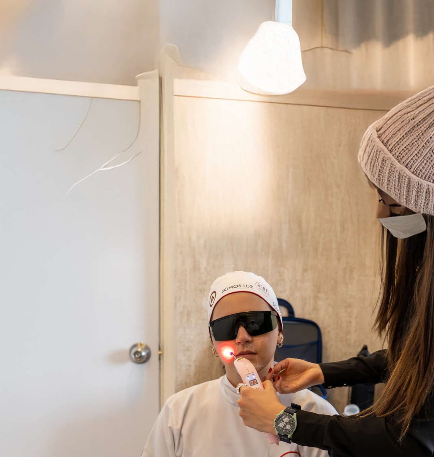 Docente aplica laserterapia a un participante con gafas de protección
